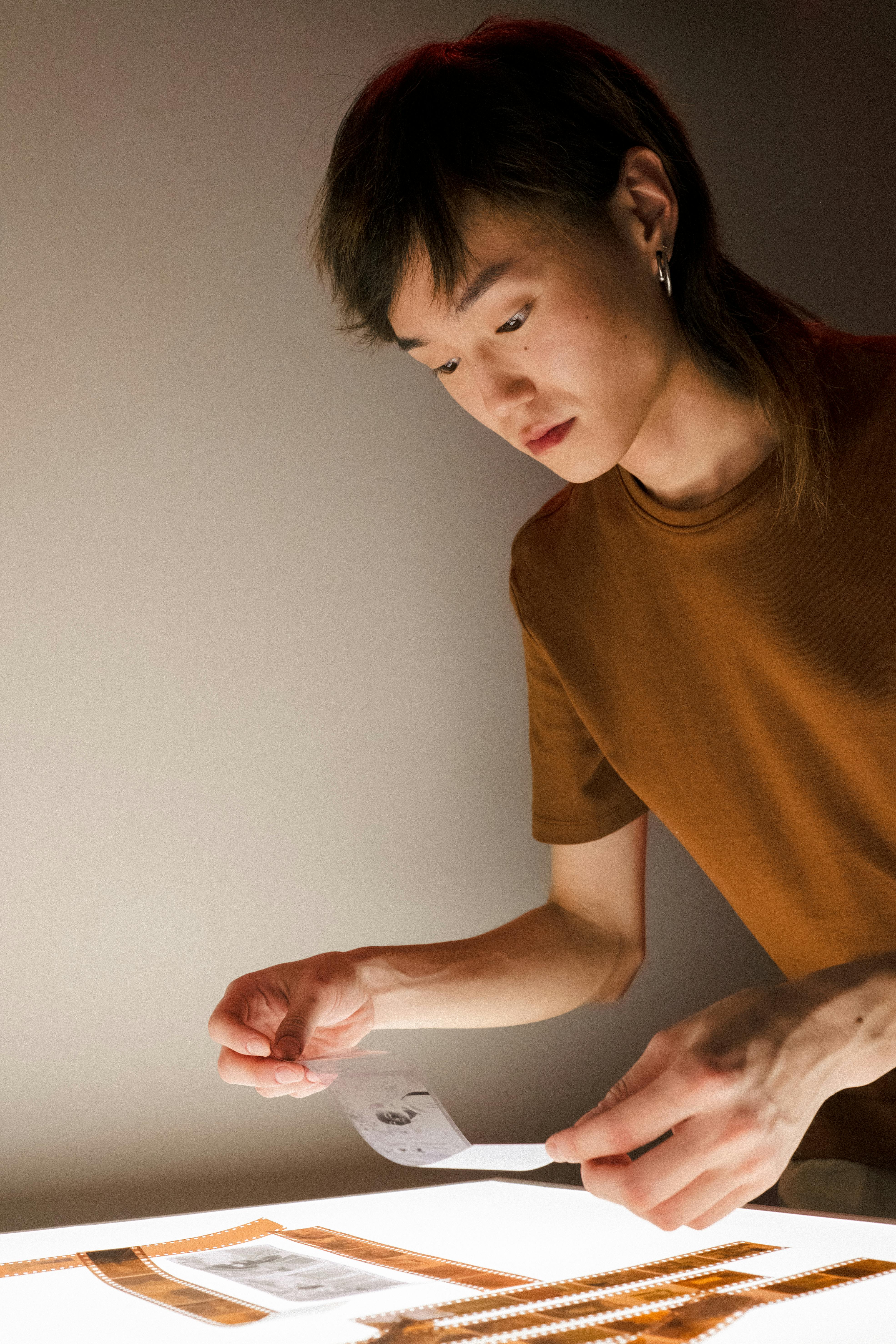 Man Developing Camera Film on Light Table · Free Stock Photo