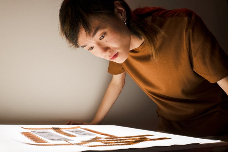 Man Developing Camera Film On Light Table