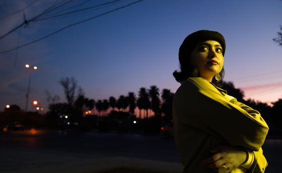 Dusk skyline behind a passer-by in a knitted hat, photo by zaid mohammed on Pexels