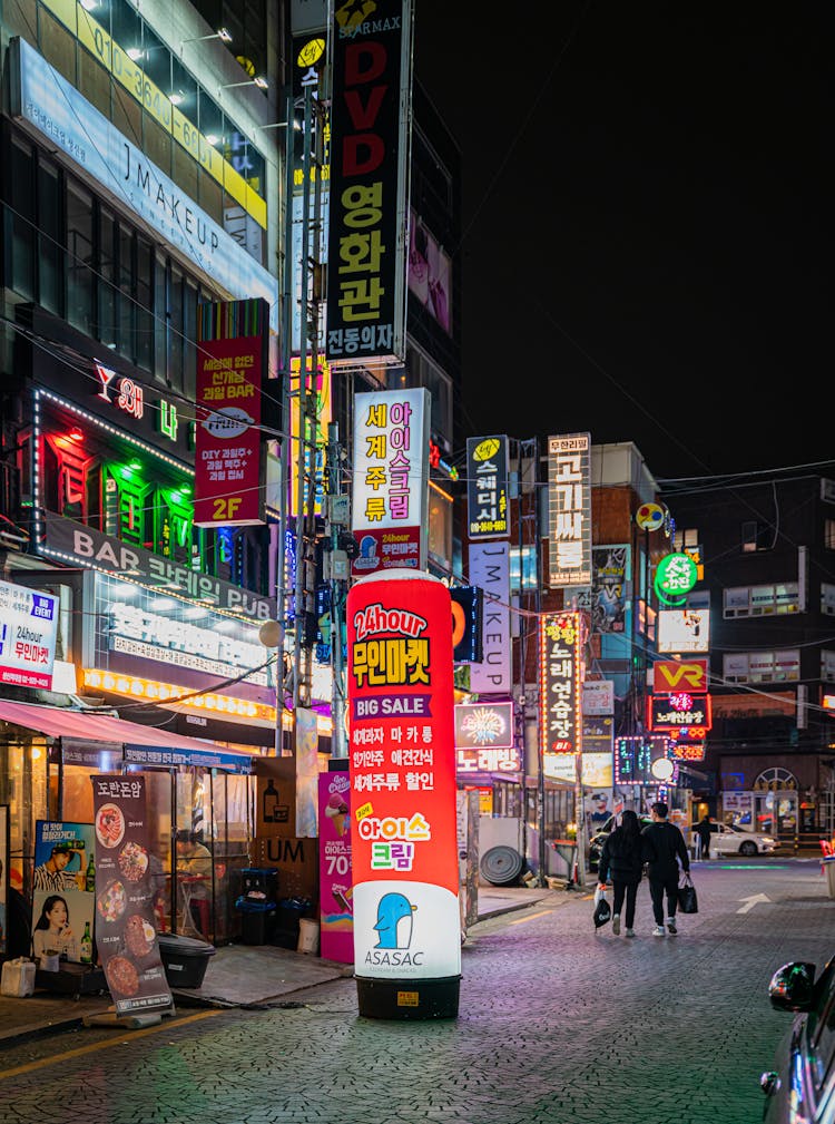 Couple Walking On Street During Night Time