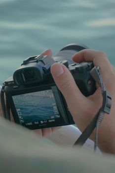 Person holding a digital camera, focusing on photography with soft background.