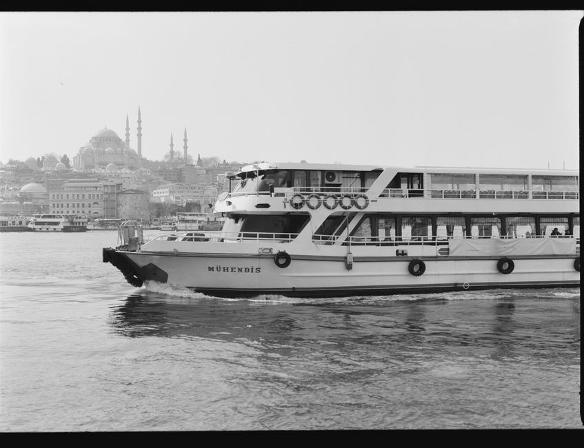 Black and white photo of a ferry in Istanbul against the city’s historic skyline.