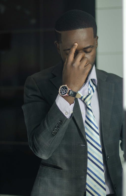 Free Man Wearing Suit with His Hand on His Face Stock Photo