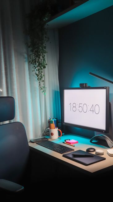 Fotomural Un elegante diseño de oficina en casa con iluminación LED, ordenador, tableta de dibujo y decoración para la productividad.