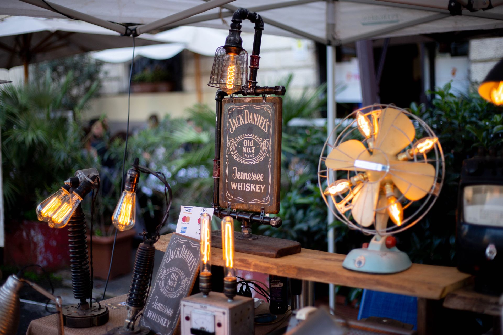 Retro display featuring Jack Daniels sign with vintage Edison bulbs and antique fan.