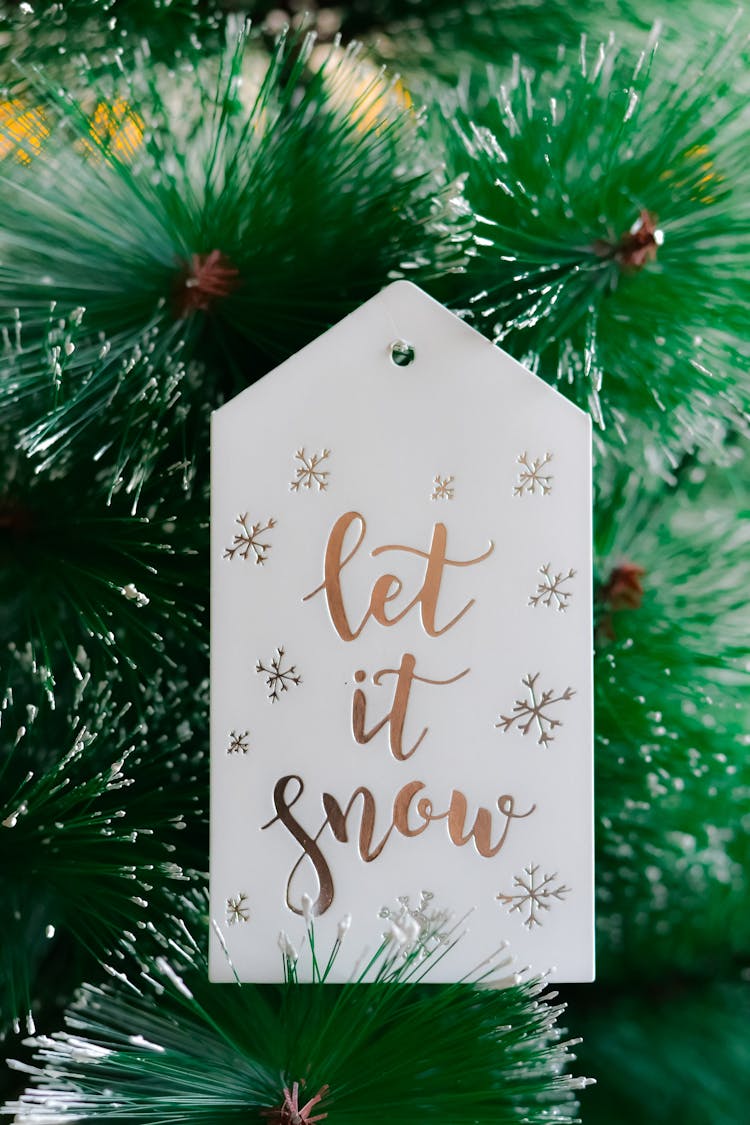 Close-Up Shot Of A White Christmas Card Hanging On A Christmas Tree