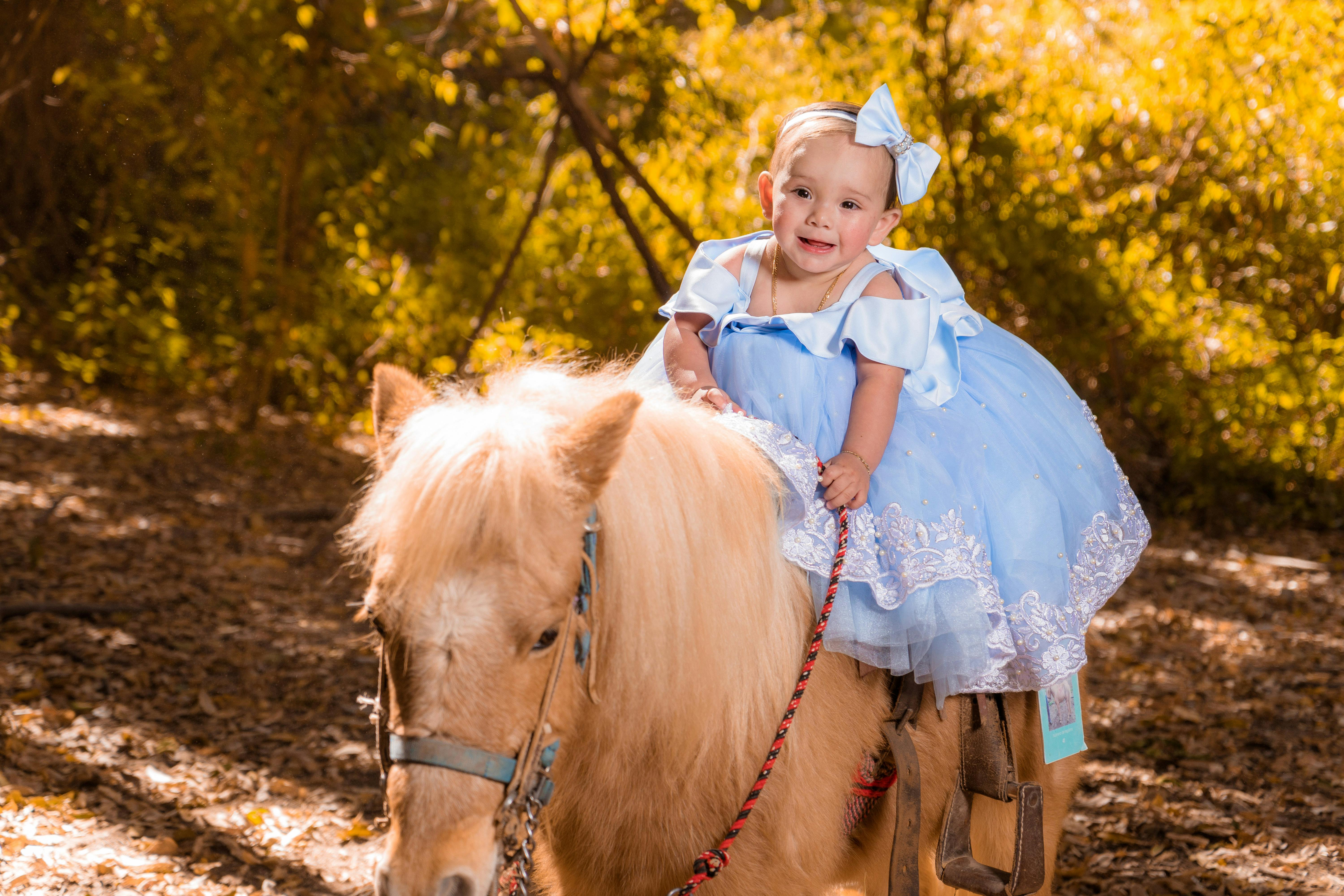 a cute girl riding a pony