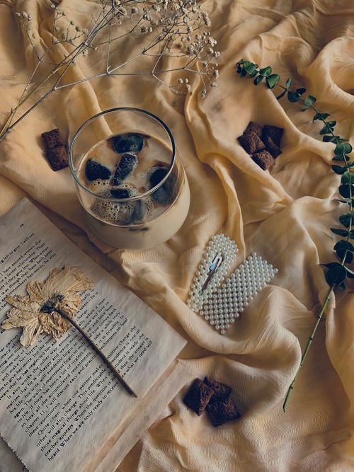 Free Iced coffee in a glass with rustic decor and dried flowers on fabric. Stock Photo