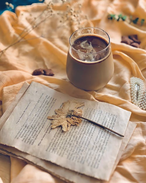 Free A High Angle View of a Coffee in a Glass Next to an Old Pages and Autumn Leave  Stock Photo