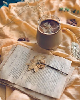A warm, autumn-themed coffee setup with a dried leaf on vintage paper, perfect for cozy vibes.