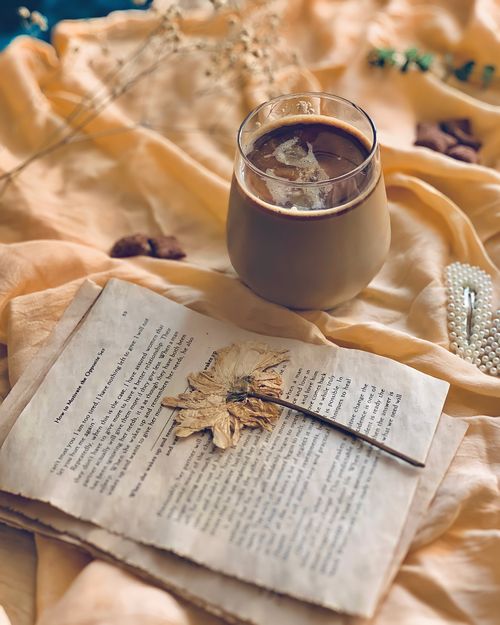 Free A warm, autumn-themed coffee setup with a dried leaf on vintage paper, perfect for cozy vibes. Stock Photo