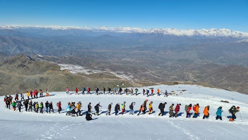 People Hiking on Snow Covered Ground
