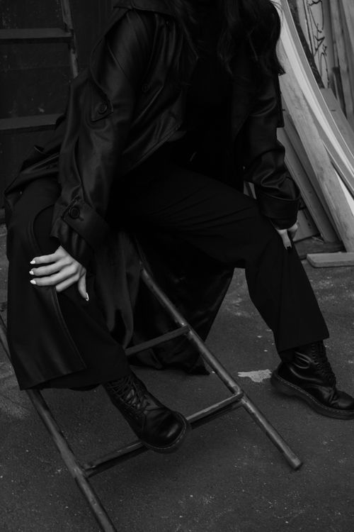 Free Black and white photo of a woman sitting on a broken ladder, showcasing urban fashion style. Stock Photo