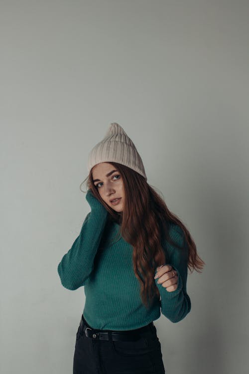 A Woman in Green Sweater and Brown Knit Cap