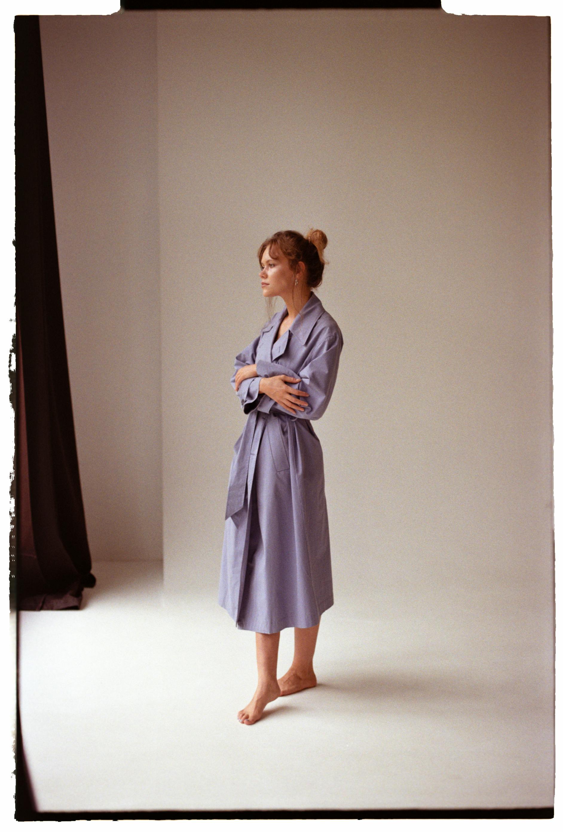A serene studio portrait of a woman in a purple dress, capturing elegance and style.