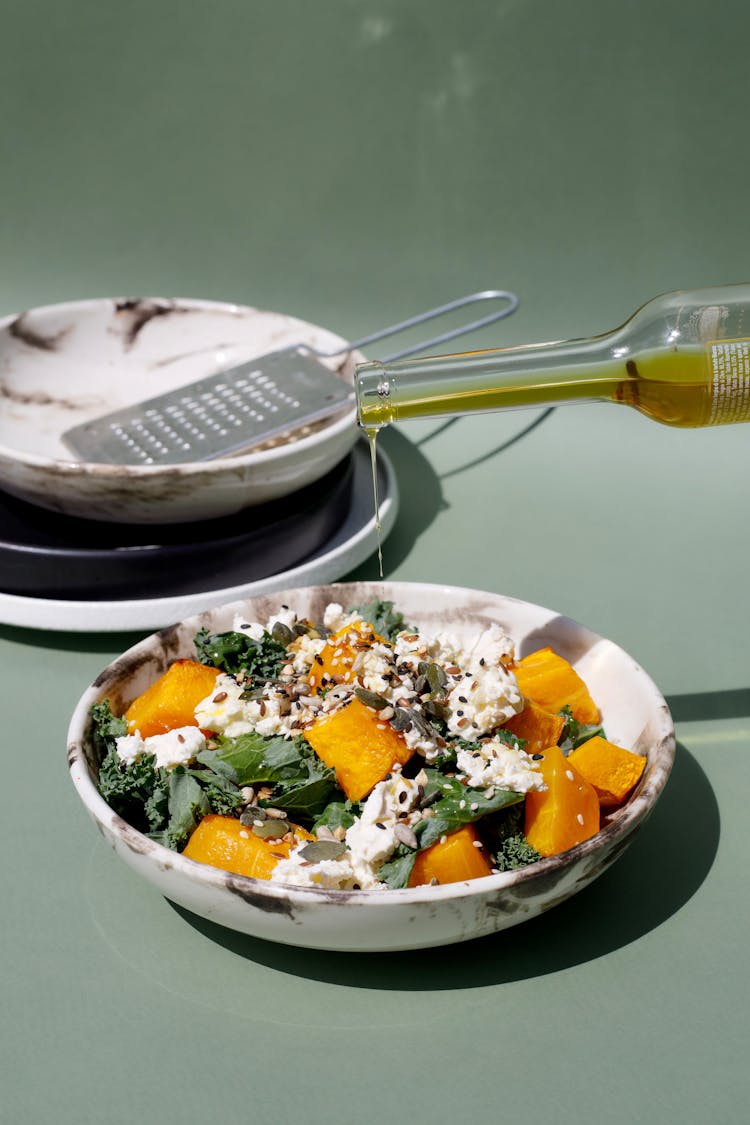 Drop Of Olive Oil Added To Salad Made Of Diced Pumpkin Lettuce And Cottage Cheese