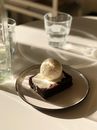 Snowball Dessert on Slice of Brownie Covered with Cream