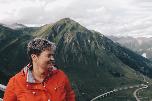 Person Wearing Windbreaker Jacket Standing Near on Mountain Range