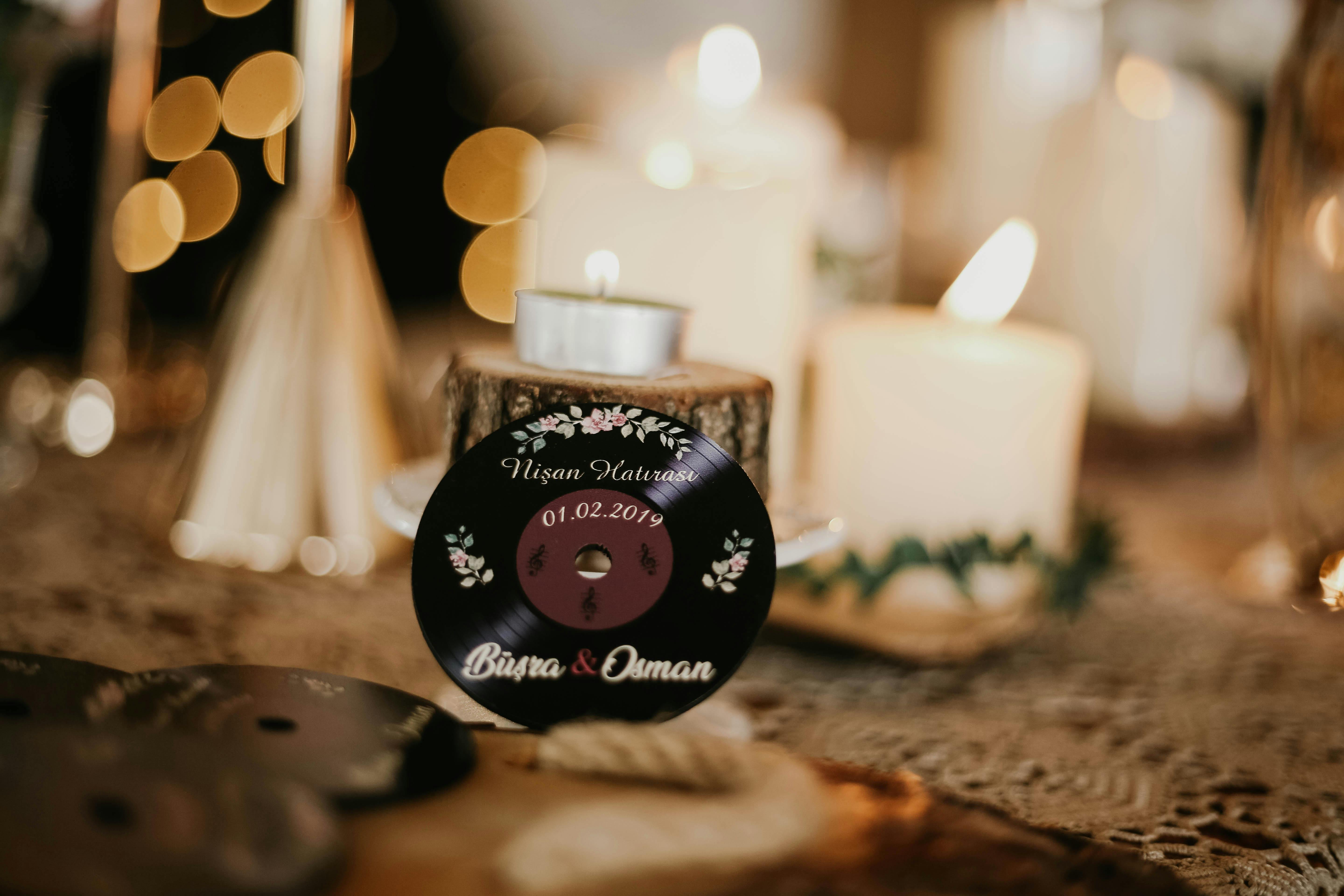 Artistic wedding decorations featuring miniature vinyl records and candles create a romantic ambiance.