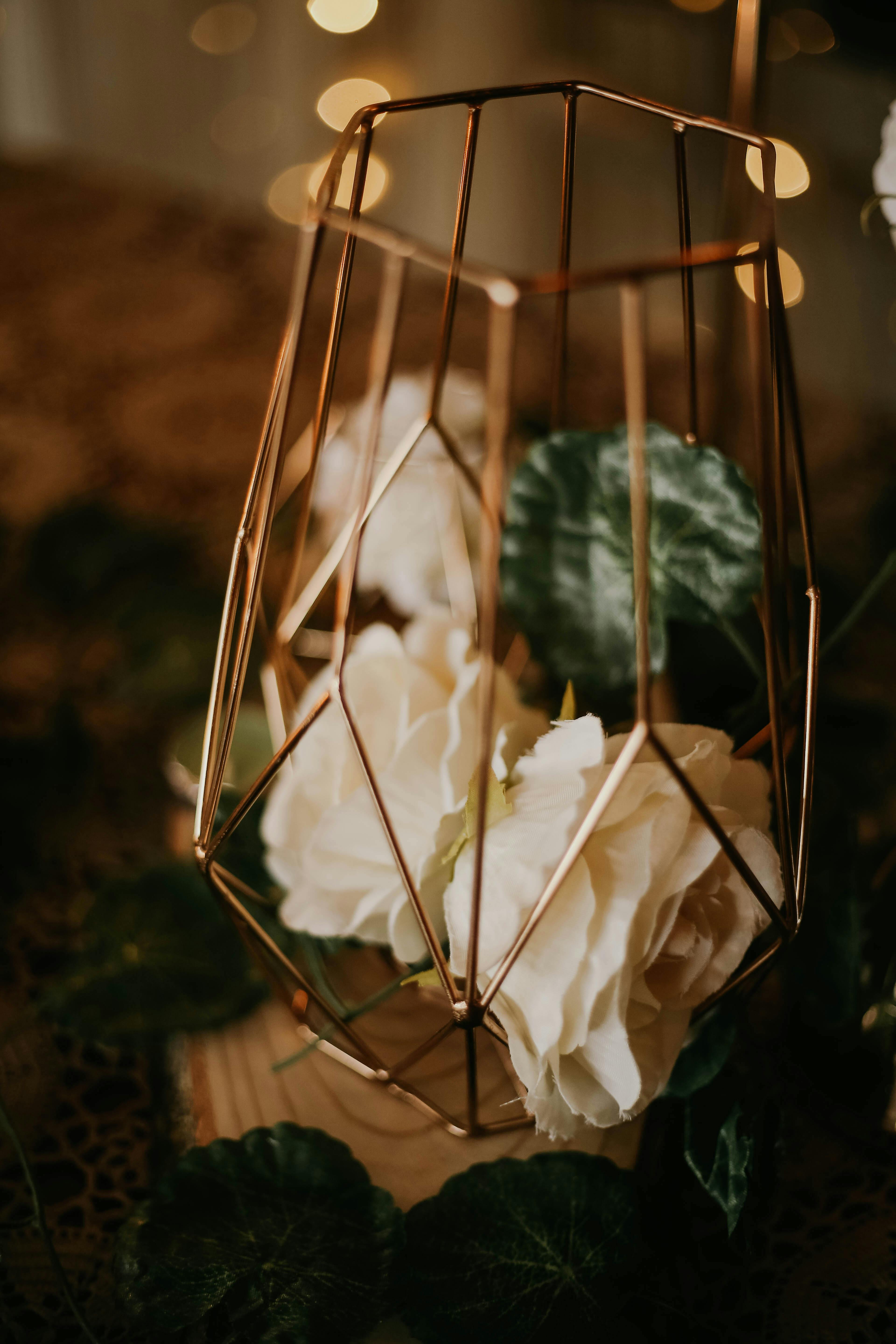 white artificial flowers in gold metal vase