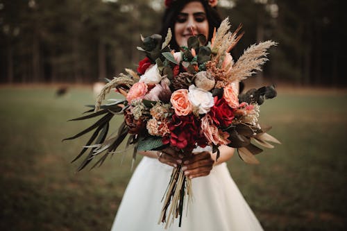 Close-Up Shot of a Woman Holding a Bouquet of Flowers