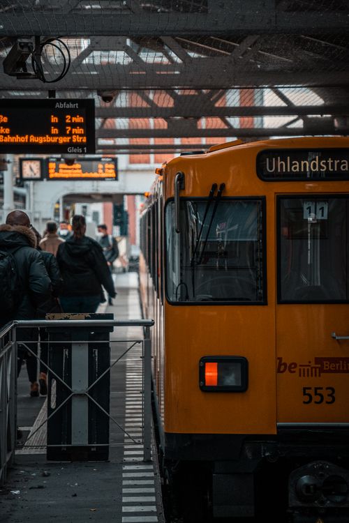 Free Commuters boarding a train at a busy Berlin station platform, exemplifying urban public transport. Stock Photo