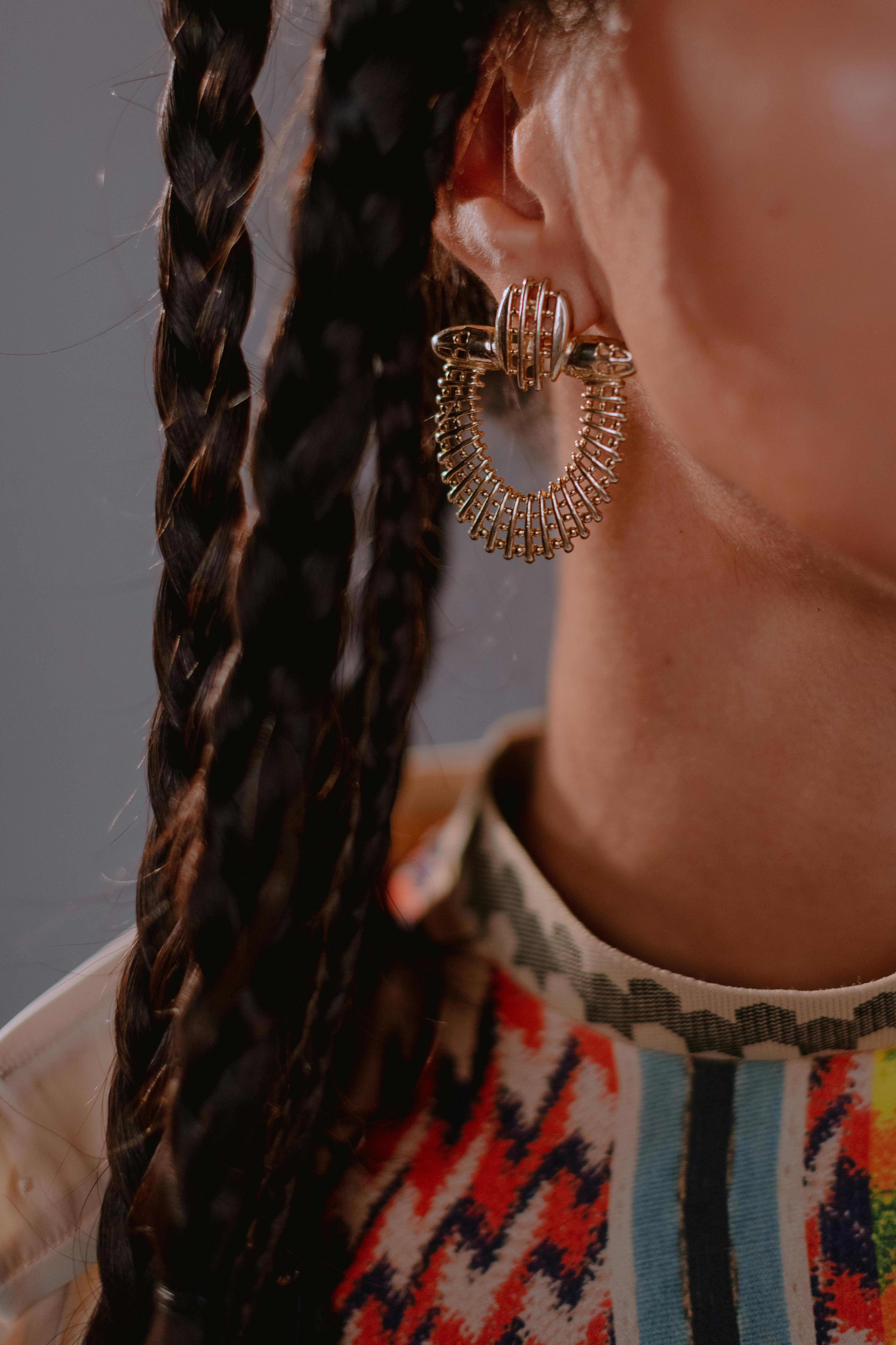 close up photo of woman wearing gold earings