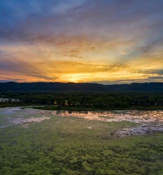 Aerial view of a stunning sunset casting vibrant colors over the Mississippi River and lush forests in Minnesota.