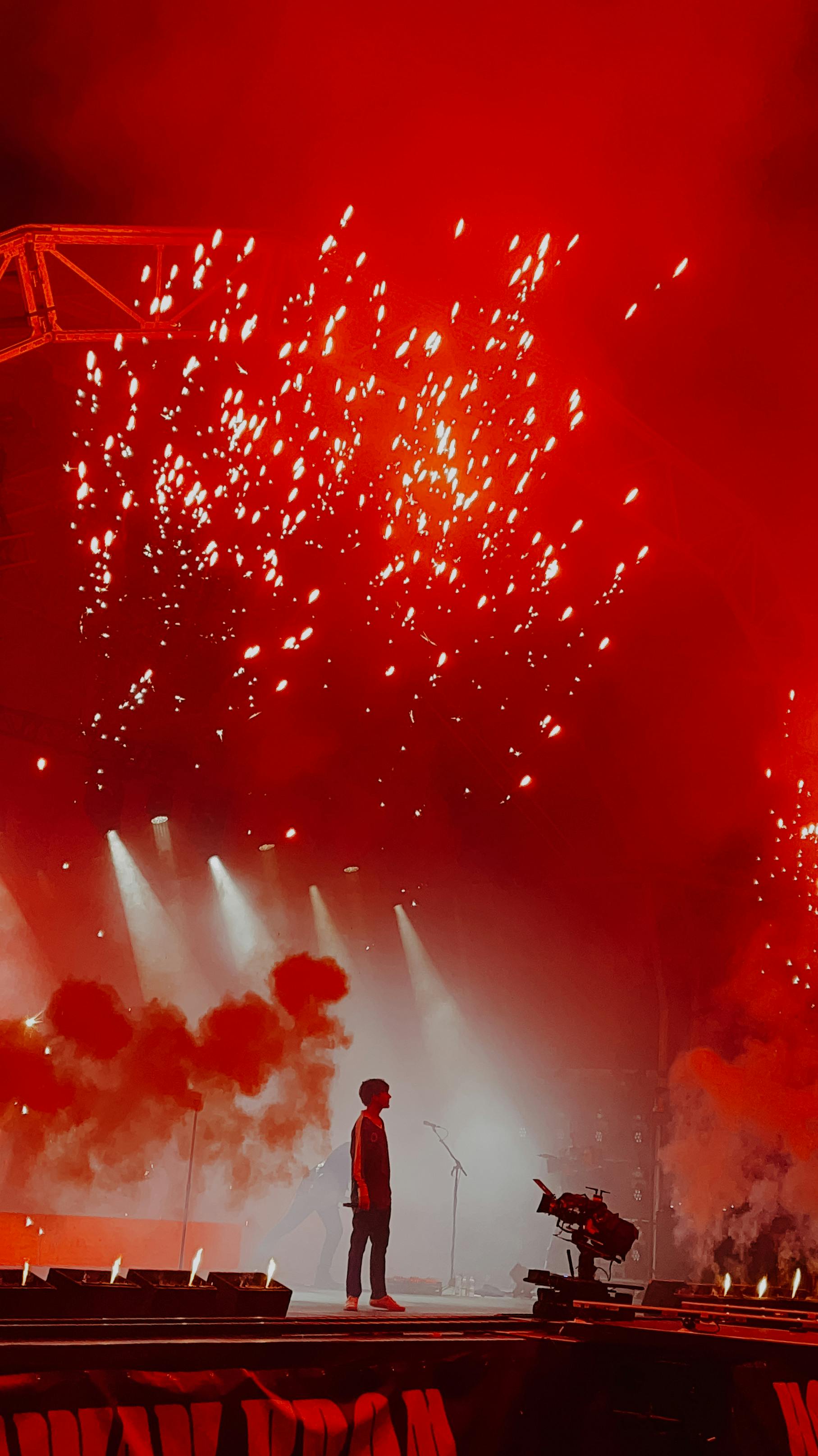 a person standing on the stage with lights and smoke