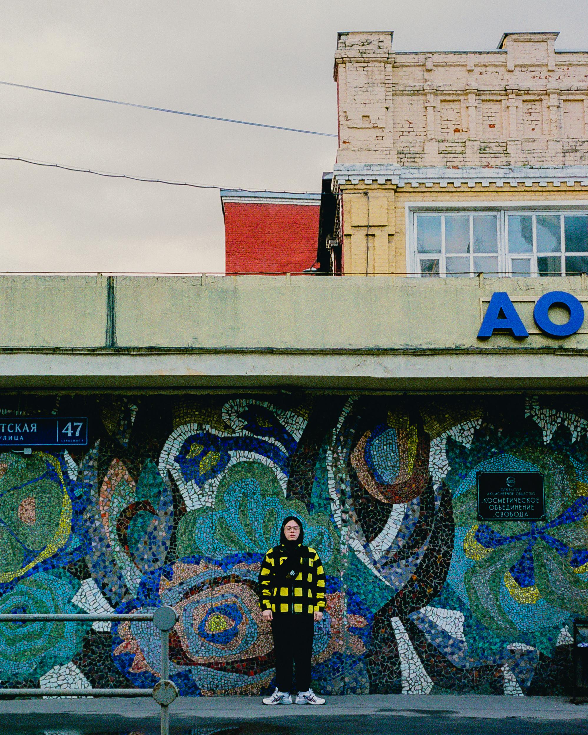 Vibrant graffiti mural on a Moscow street with a person in the foreground.