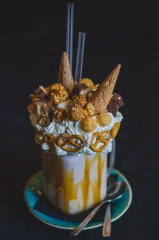 这款奢华奶昔，上面撒有焦糖、椒盐卷饼、爆米花和华夫饼蛋卷