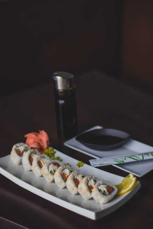 Free Tasty sushi rolls served with soy sauce, ginger, and wasabi on a dark background. Stock Photo
