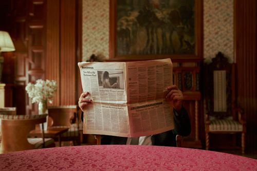 Free Person reading a newspaper in a luxurious, old-fashioned interior. Stock Photo