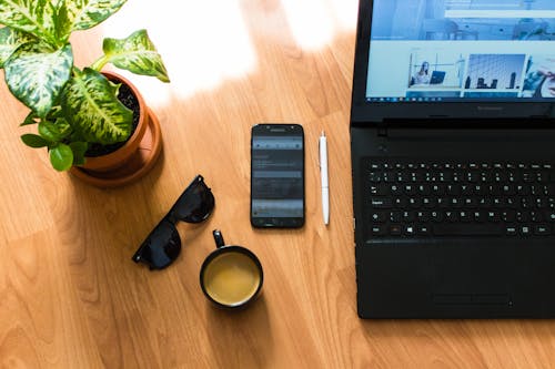 Black Sunglasses With Black Frames Beside Black Smartphone