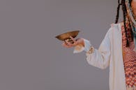 A woman in a white cardigan holds a singing bowl, embodying serenity and mindfulness.