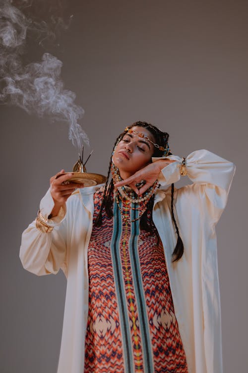 A Woman in White Robe Holding an Incense