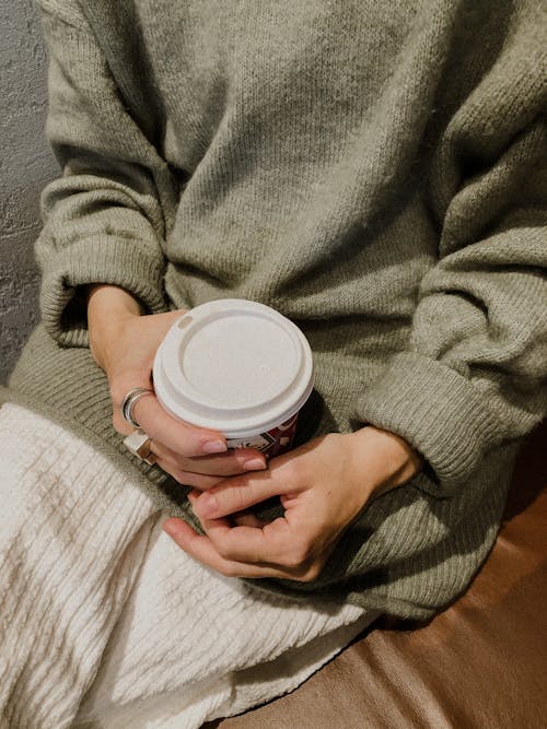 Hands of a Person Holding a Disposable Cup