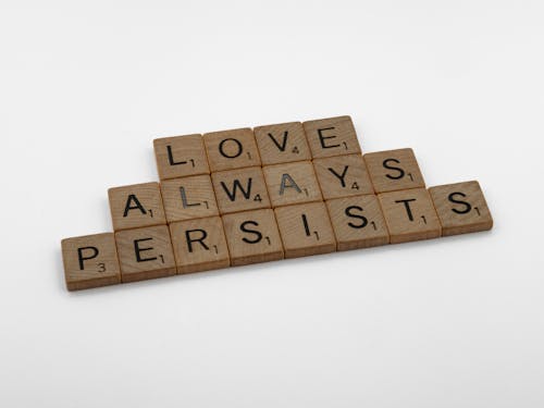 Close-Up Shot of Scrabble Tiles on a White Surface 