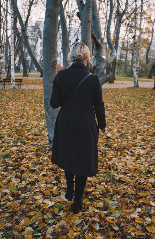 Woman in Black Coat Standing on Near a Tree
