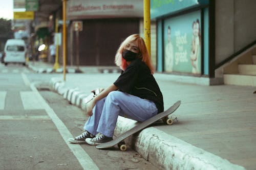 A Woman in a Black Shirt Sitting Beside the Street