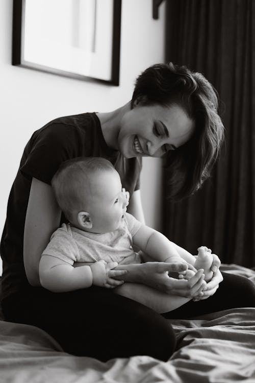 Free Grayscale Photo of a Mother Playing with Her Baby Stock Photo