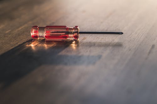 Free Red Screw Driver on Brown Wooden Surface Stock Photo
