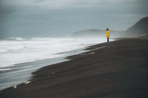 Person in Raincoat at Seashore