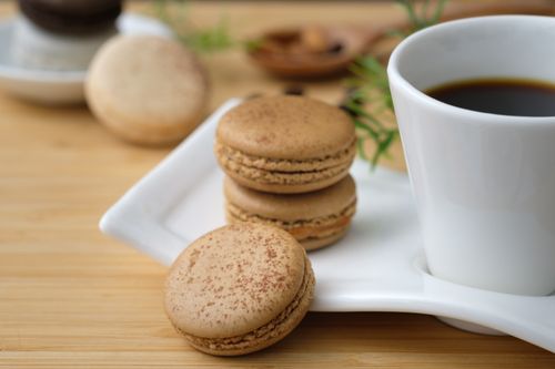 Free A close-up of French macarons served with a cup of coffee, perfect for a gourmet dessert setting. Stock Photo
