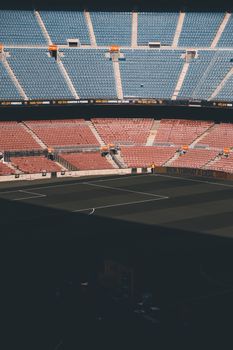 A scenic view of a deserted stadium with multicolored seating and vibrant lighting.
