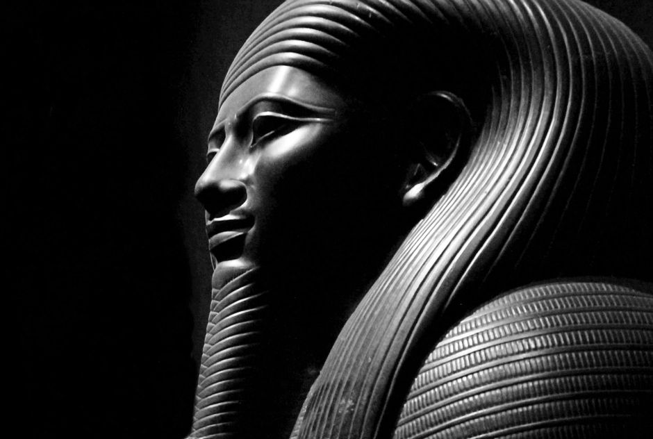 Close-up of a black and white ancient Egyptian statue with intricate carvings.