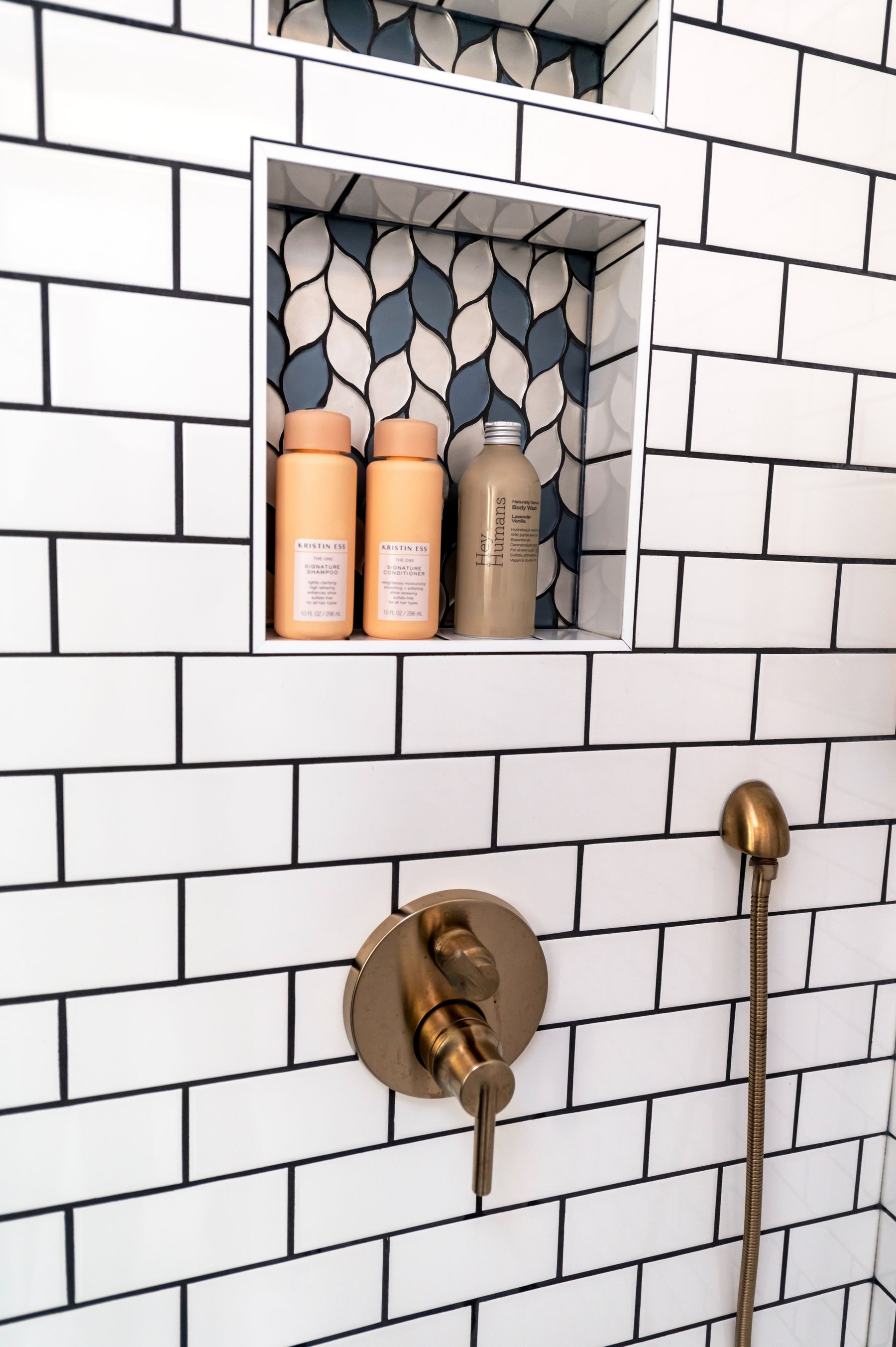 Bathroom shower with brass fixtures and geometric tile