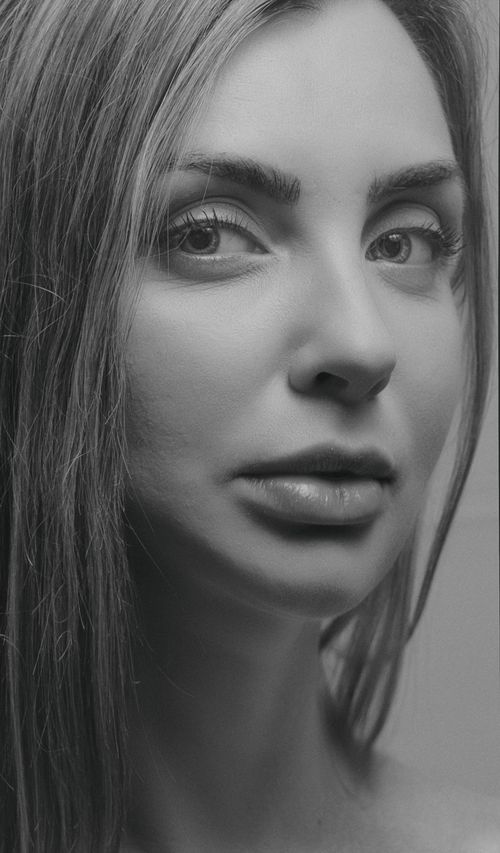Free Artistic black-and-white close-up portrait capturing the elegance of a woman. Stock Photo