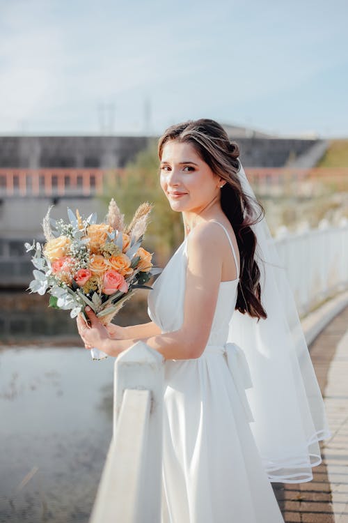 A Smiling Bride Posing with a Bouquet of Flowers