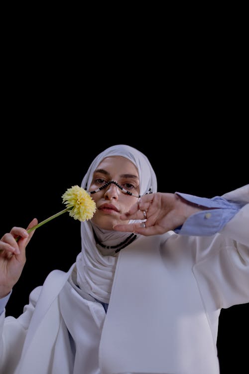 Free A Woman Holding a Yellow Flower Stock Photo